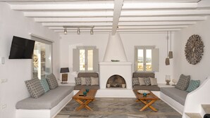 A modern living room with a fireplace, two sofas, and a television. - Villa Orion Mykonos - Blue Views Mykonos Villas (Mykonos)
