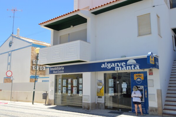 A building with a sign for 'Imobiliária Real Estate' and 'algarve manta' on the facade.