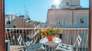 A balcony with a potted plant and a white table. - PIAZZA DI SPAGNA APARTMENT (Roma)