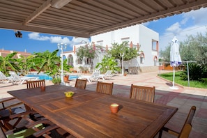 A covered outdoor area with a pool, lounge chairs, and a table with chairs. - Beautiful villa Ramos in San Antonio Bay with BBQ and large pool (Sant Josep de Sa Talaia / San Jose)
