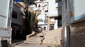 Una calle estrecha con escalones de piedra que conducen a un edificio con un letrero que dice 'Calle de la Moraira'.