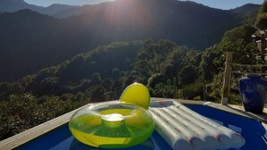 A pool with inflatable rings and a large vase, surrounded by lush greenery and mountains. - U vene e posa - the Pinzelli mountain.  (Lugo-Di-Nazza)