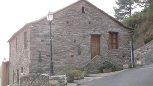 A stone building with a sloped roof, a wooden door, and a small window. - U vene e posa - the Pinzelli mountain.  (Lugo-Di-Nazza)