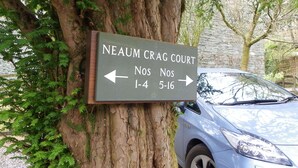 A sign for Neaum Crag Court with directional arrows pointing to Nos 1-4 and 5-16. - Paradise in the Lake District. (Skelwith Bridge, Ambleside)