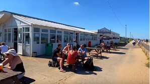 A beachside pavilion with tables and benches for visitors.