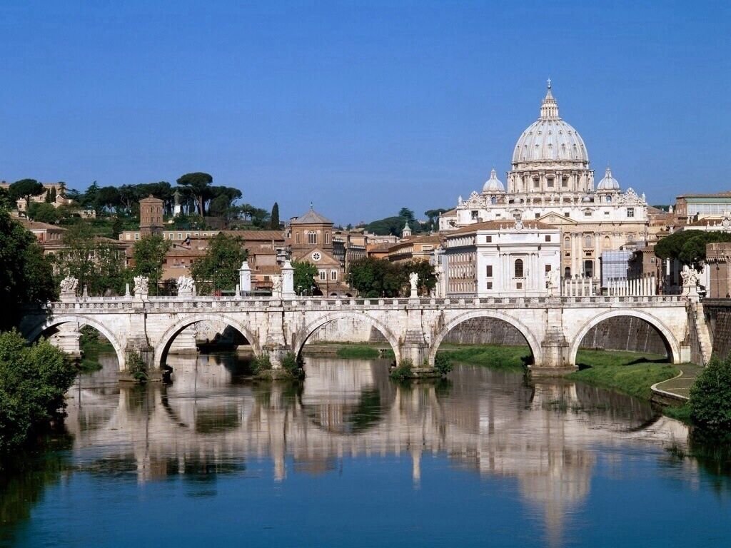 Un pont historique aux arches élégantes enjambant une rivière paisible, dont l’architecture se reflète dans l’eau.