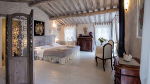 A bedroom with a large bed, a wooden wardrobe, a chair, and a desk with a lamp. - Torretta - Luxury rustico with pool and air conditioning EV wallbox (Camaiore)
