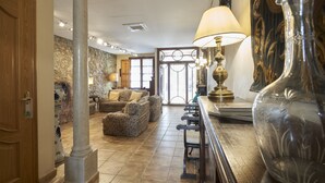 Un salon spacieux avec un grand canapé, une table basse et un vase décoratif.