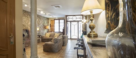 Un salón amplio con un sofá grande, una mesa de centro y un jarrón decorativo.
