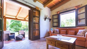 A cozy room with a wooden ceiling, a sofa, a coffee table, and a view of greenery outside. - ClickSardegna Villa Porticciolo near the beach for 6 people, with A/C and WiFi (Alghero)