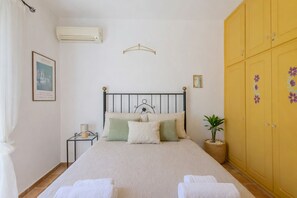 Une chambre bien rangée, avec un lit, une table de chevet et une armoire.