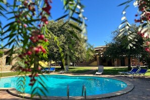 Alberca al aire libre y camastros 