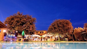 Eine Outdoor-Veranstaltung mit Schwimmbad, Zelten und Bäumen.