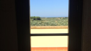 Une vue à travers une porte, avec un sol en briques et un ciel dégagé.