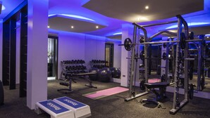 A gym with weightlifting equipment, dumbbells, and exercise balls. - Boracay Suites (Boracay Island)
