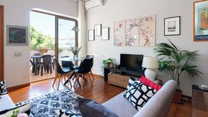 Un salon moderne avec un canapé, un téléviseur et un coin repas.