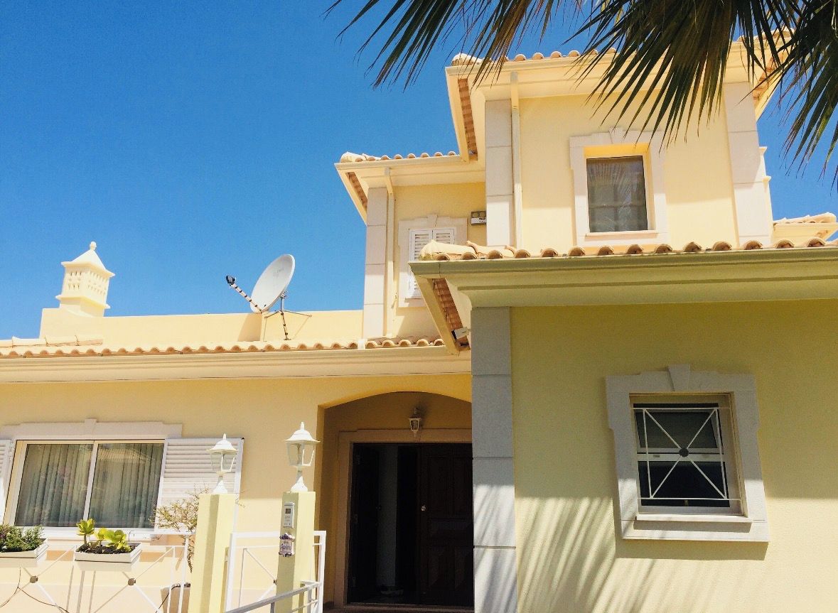 A building with a satellite dish, a balcony, and a door.