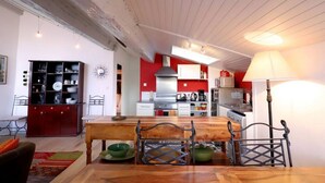 Una cucina con un tavolo da pranzo, sedie e una parete rossa.