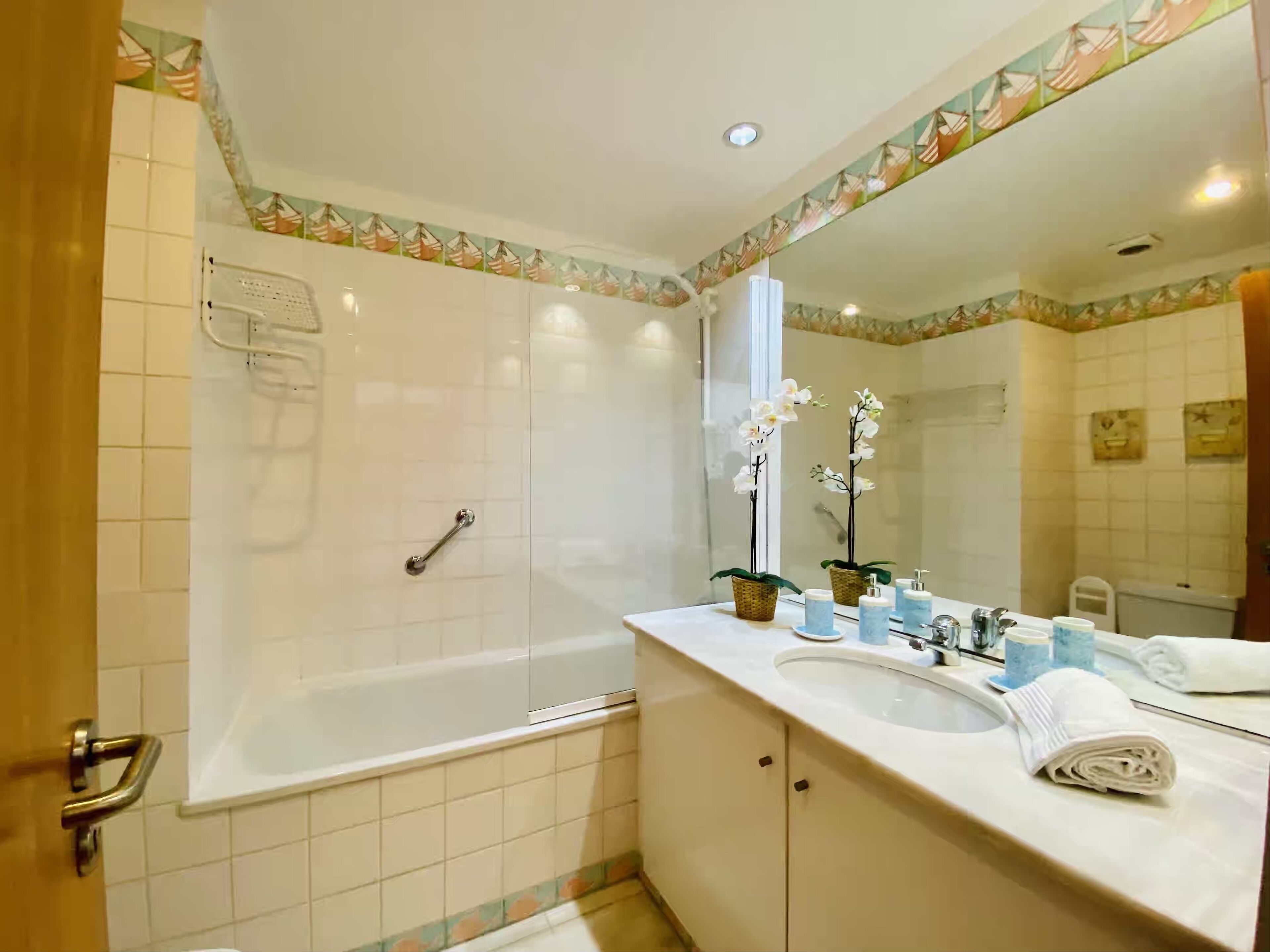 A bathroom with a bathtub, a sink, a mirror, and a shower.