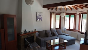 A living room with a fireplace, a sofa, a glass coffee table, and a television. - 4 Bedroom villa, up to 10 people, Private pool & BBQ close to beaches and Calpe (Calpe)