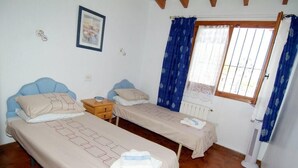 A bedroom with two beds, a radiator, a window with curtains, and a wall-mounted picture. - 4 Bedroom villa, up to 10 people, Private pool & BBQ close to beaches and Calpe (Calpe)