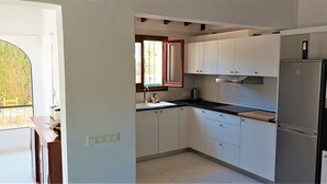 A compact kitchen with white cabinets, a black countertop, and a built-in stainless steel refrigerator. - 4 Bedroom villa, up to 10 people, Private pool & BBQ close to beaches and Calpe (Calpe)