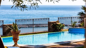 A swimming pool with a view of the sea, surrounded by a metal fence and a grassy area. - Villa Alba 12, Emma Villas (Giardini Naxos)