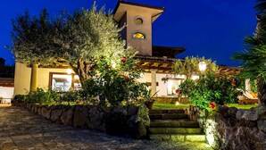 A building with a stone staircase leading to a door, surrounded by greenery and stone walls. - Villa Alba 12, Emma Villas (Giardini Naxos)