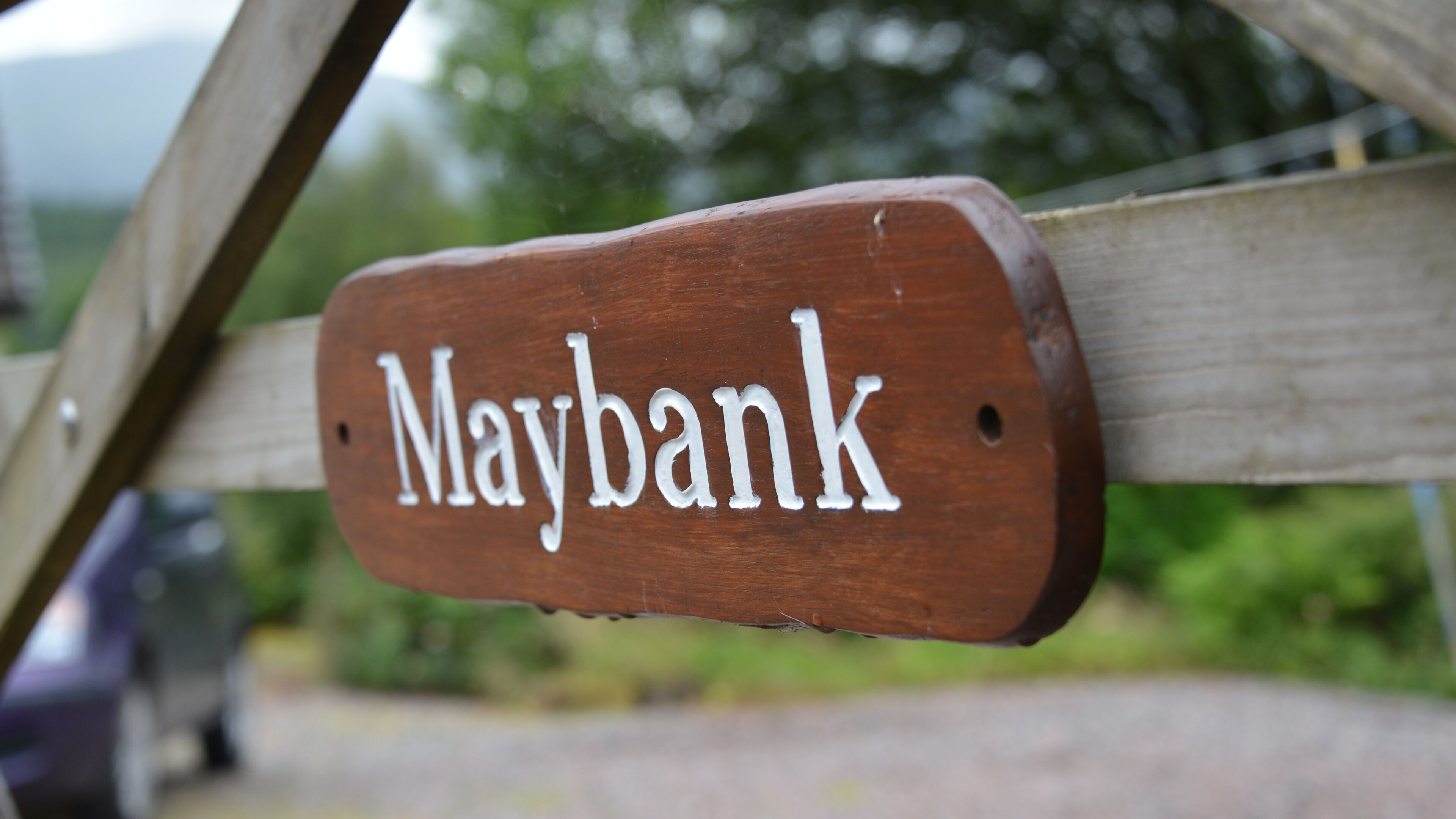 A wooden sign with the name "Maybank" on it.