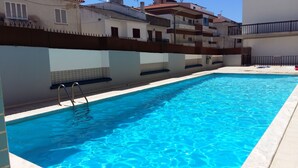 A rectangular swimming pool with clear blue water, surrounded by a tiled deck. - T2 by the beach, with pool, WIFI and cable TV, in Praia do Pedrogão (Coimbrão)