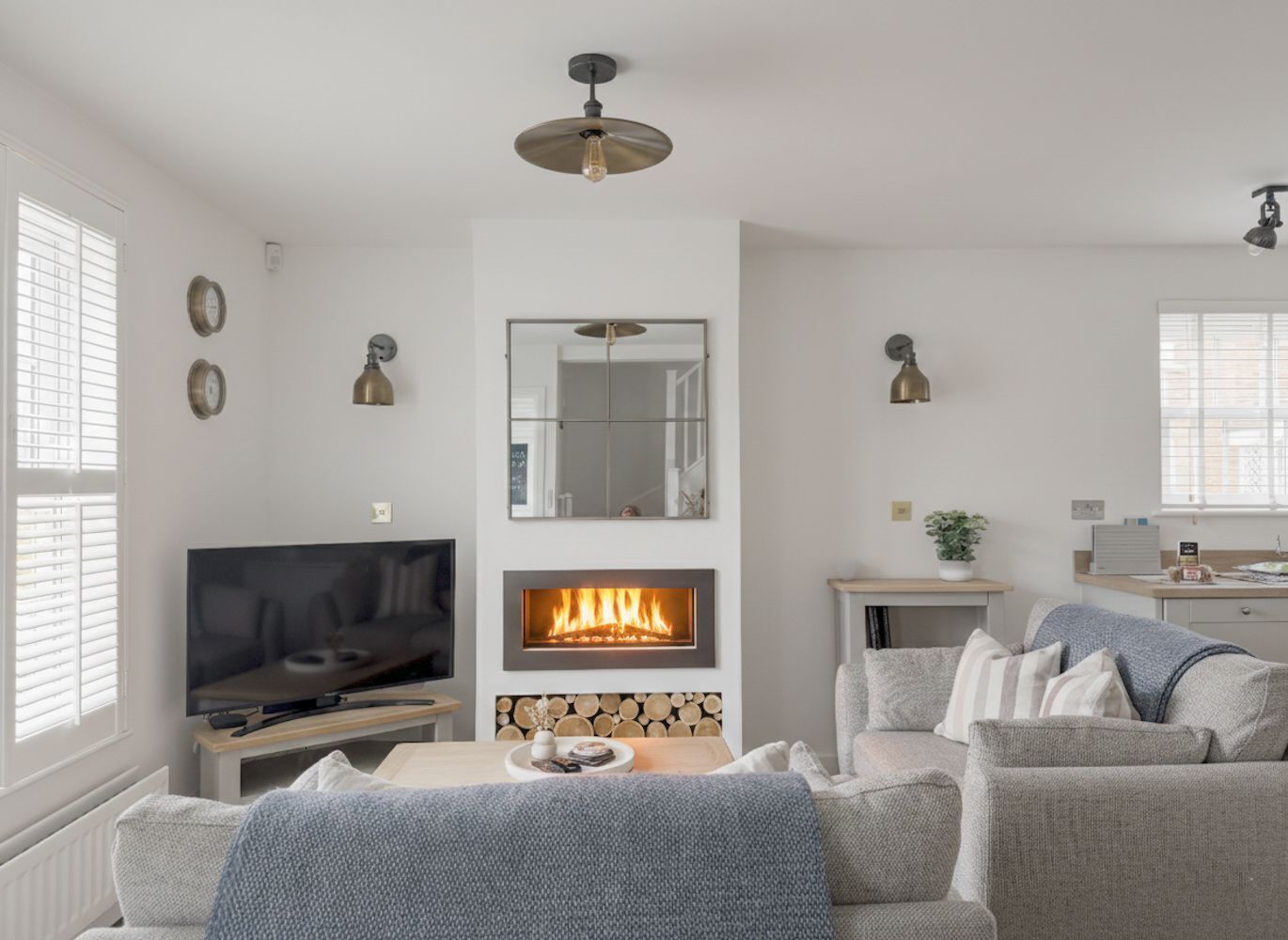 A modern living room with a fireplace, a television, and a dining area.