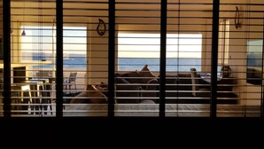 A room with a view of the sea, featuring a sofa, a dining table, and a chair. - Waterfront duplex 150m2 12/14 pax, magnificent sea view. (Hyères)