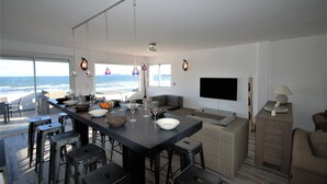 A modern kitchen with a large island, bar stools, and a view of the ocean. - Waterfront duplex 150m2 12/14 pax, magnificent sea view. (Hyères)