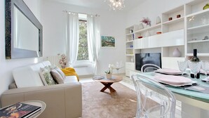 A modern living room with a sofa, coffee table, and dining area.