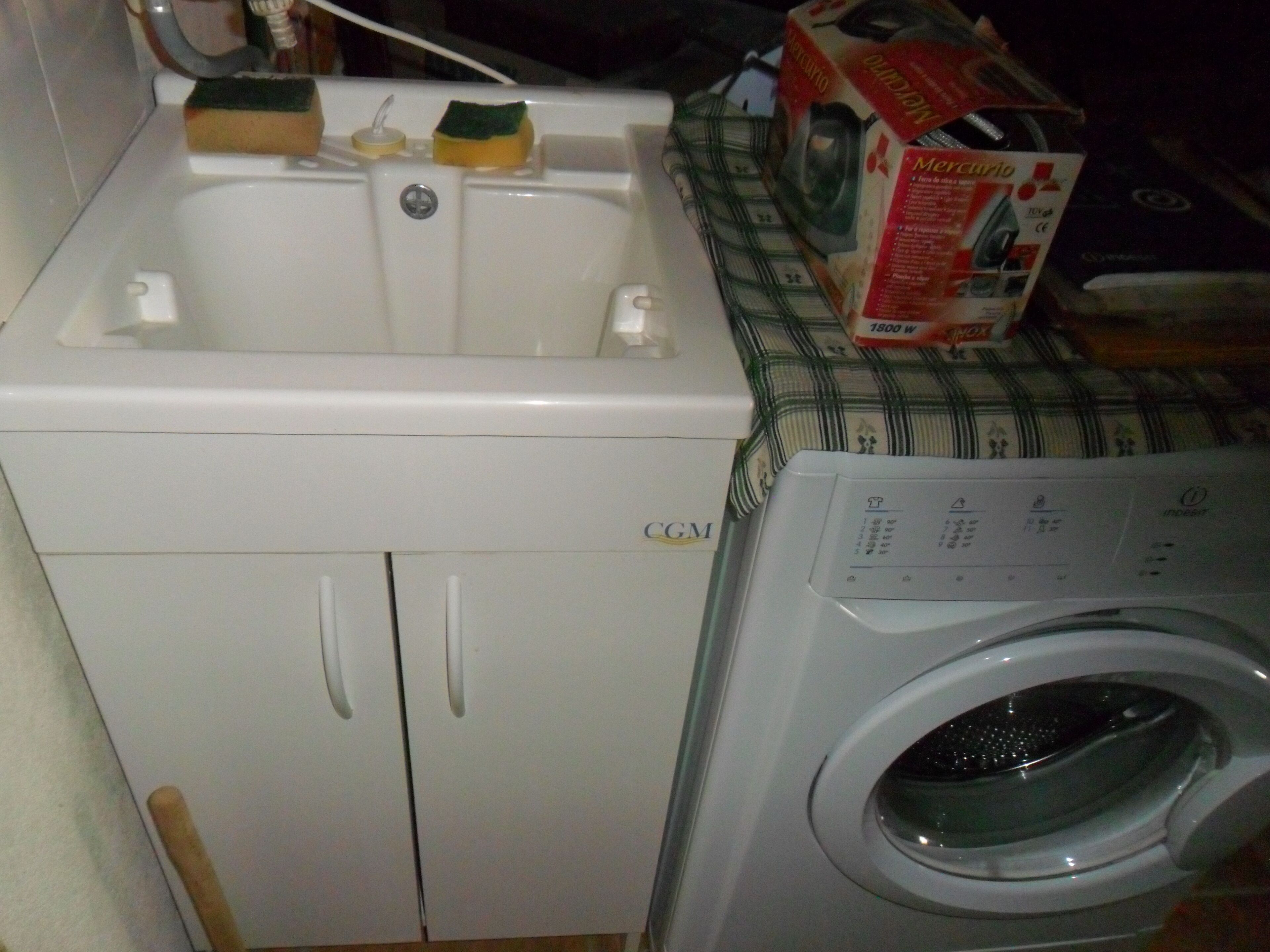 A laundry area with a washing machine and a sink.