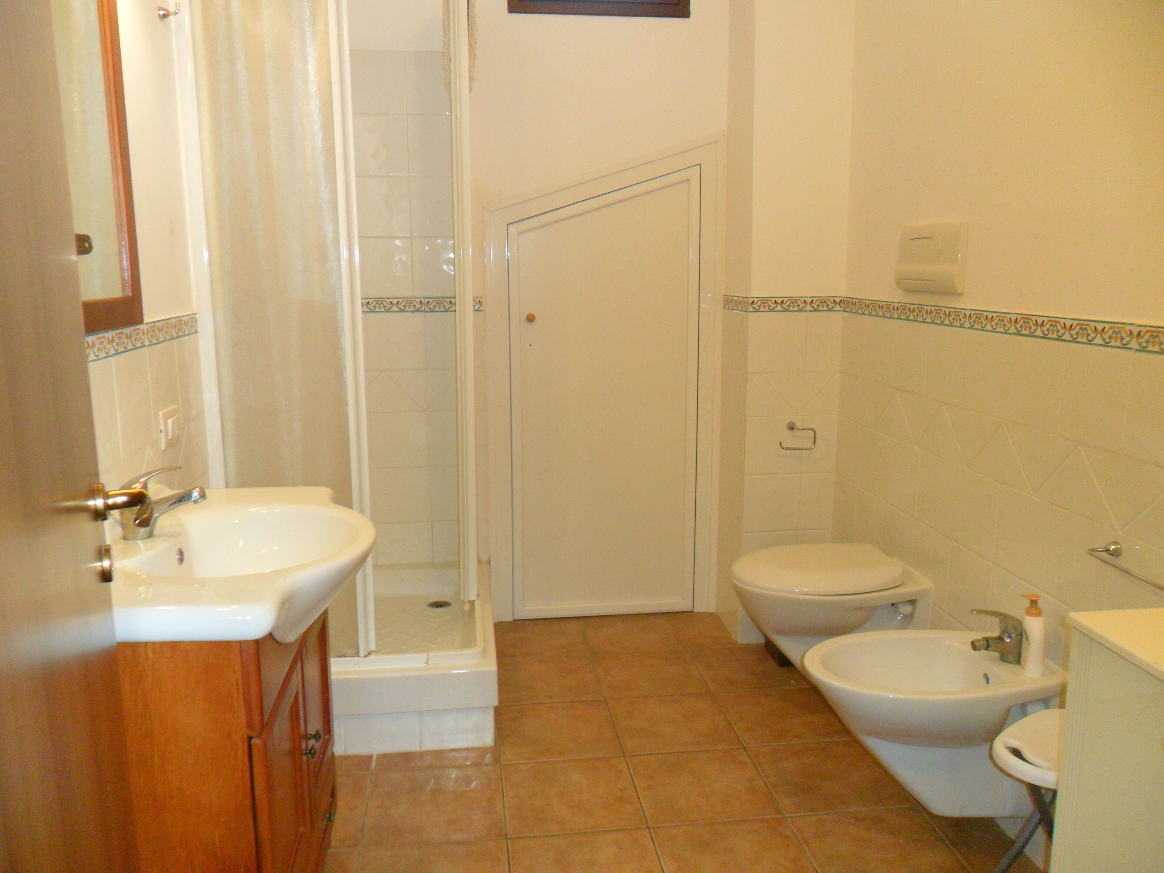 Ein Badezimmer mit Dusche, Toilette, Bidet und Waschbecken.
