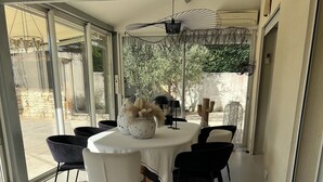 A modern dining area with a round table, black and white chairs, and a patterned rug. - Large air-conditioned house, swimming pool Secure Very quiet Pétanque, Table tennis (Saïx)