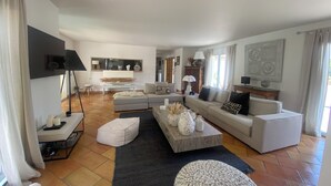 A spacious living room with a large sofa set, a coffee table, and a television mounted on the wall. - Large air-conditioned house, swimming pool Secure Very quiet Pétanque, Table tennis (Saïx)