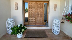 A wooden double door with a geometric pattern, flanked by two white, woven planters. - Large air-conditioned house, swimming pool Secure Very quiet Pétanque, Table tennis (Saïx)