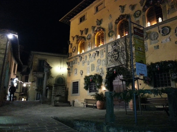 A historic building with stone facades, multiple windows, and outdoor seating areas.