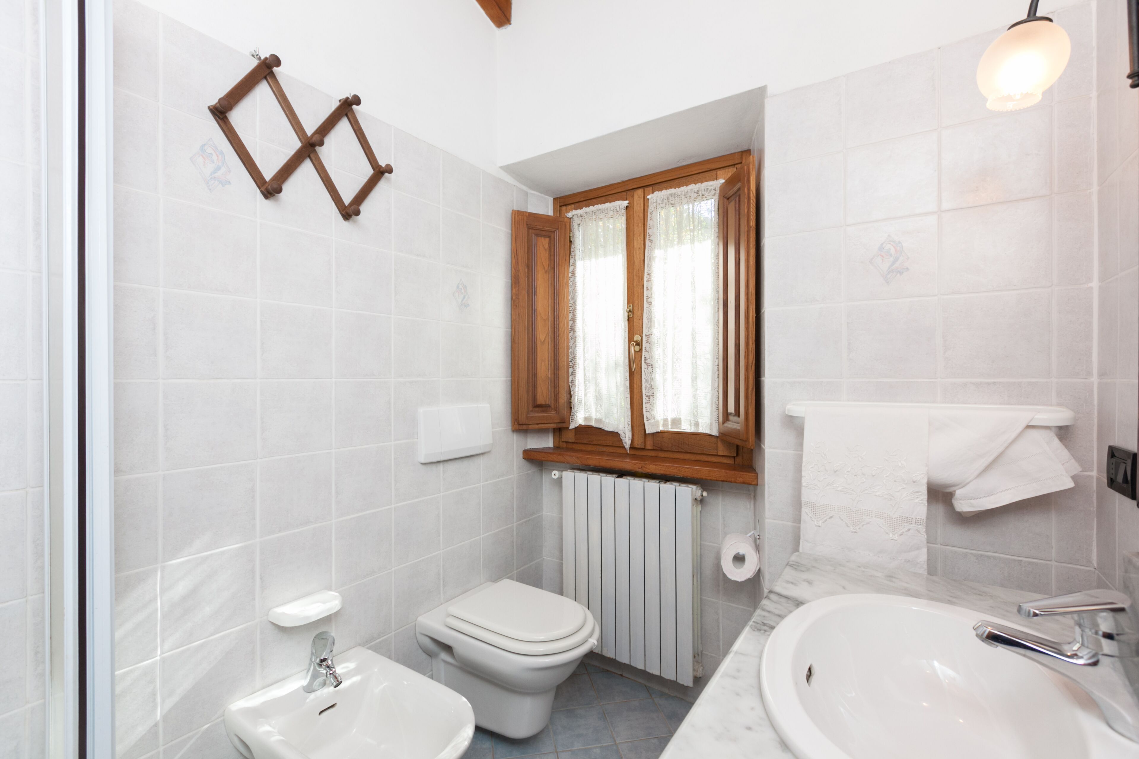 Un baño con inodoro, lavabo y zona de ducha.