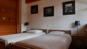 A double bed with white bedding, a wooden headboard, and two bedside tables with lamps.