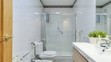 Een bad/douchecombinatie, een haardroger, een bidet, handdoeken