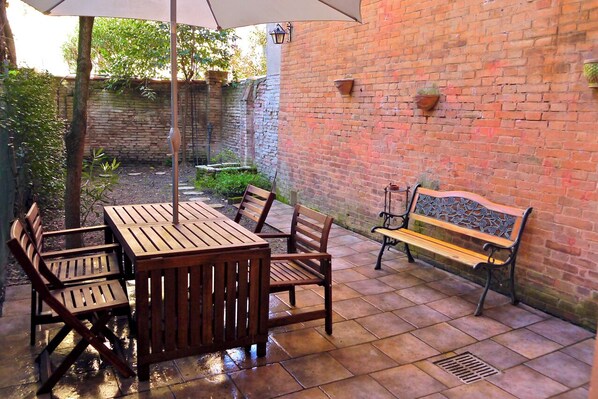 Relax on the patio surrounded by lush greenery and enjoy the tranquil atmosphere.