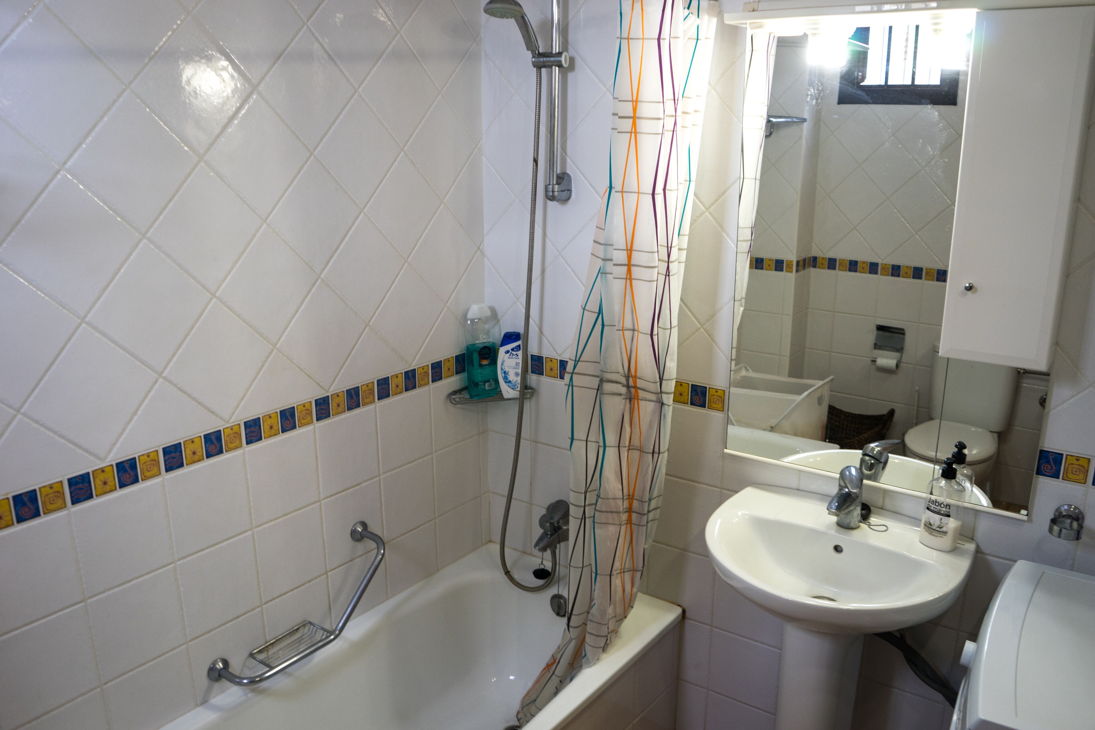 Een badkamer met een bad, een wastafel en een spiegel.