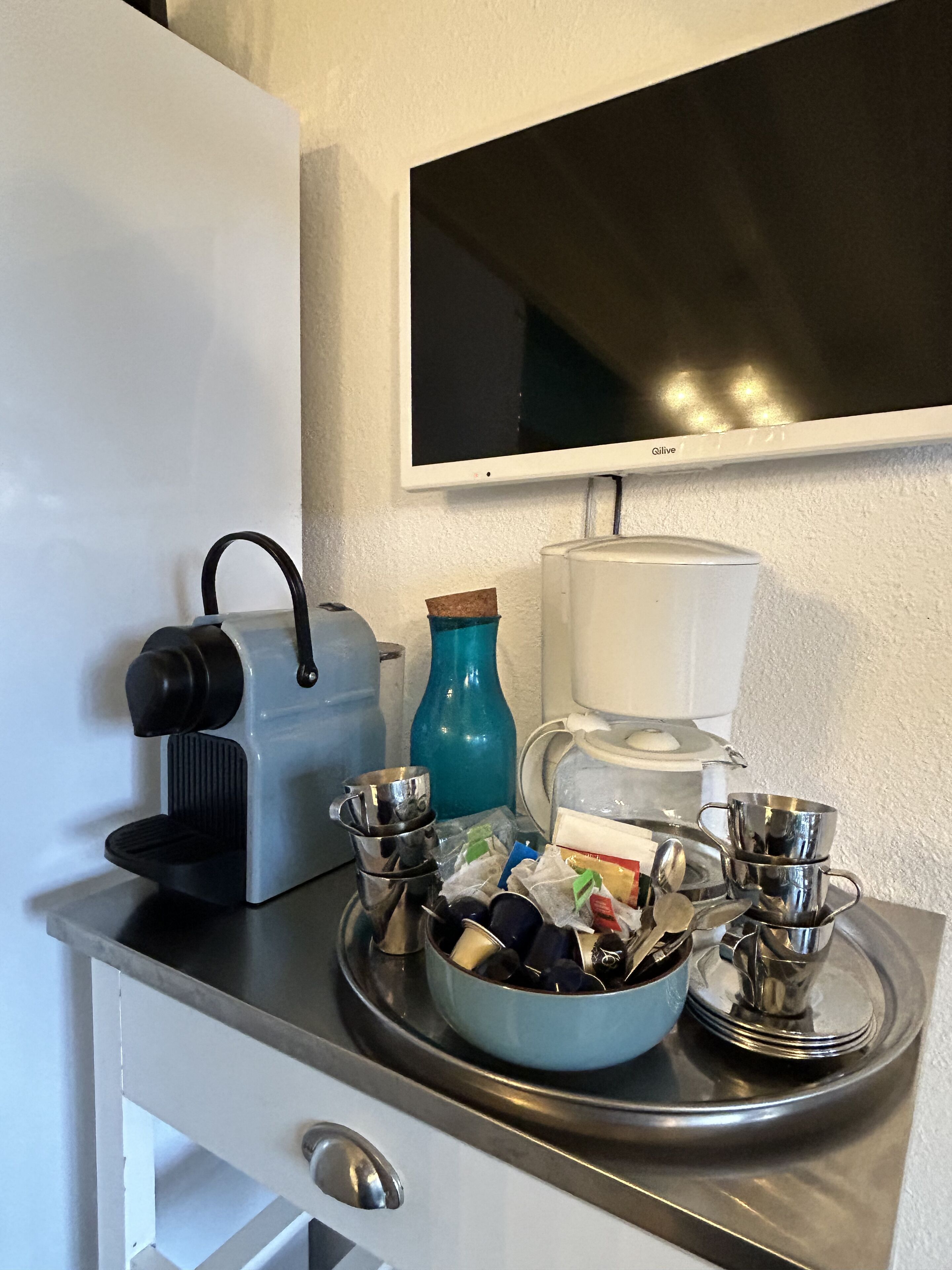 Eine Küchenzeile mit Kaffeemaschine, Wasserkocher und Kaffeekanne auf einer Ablagefläche.