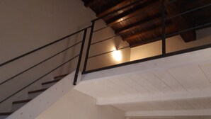 A staircase with a wooden handrail and a white wall.