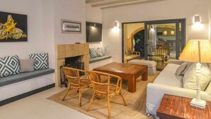 A modern living room with a sofa, a wooden coffee table, wicker chairs, a fireplace, and a television. - New house: Heated swimming pool, large BBQ, 100MB wifi, air conditioning (Tosalet, El (Javea/Xabia))