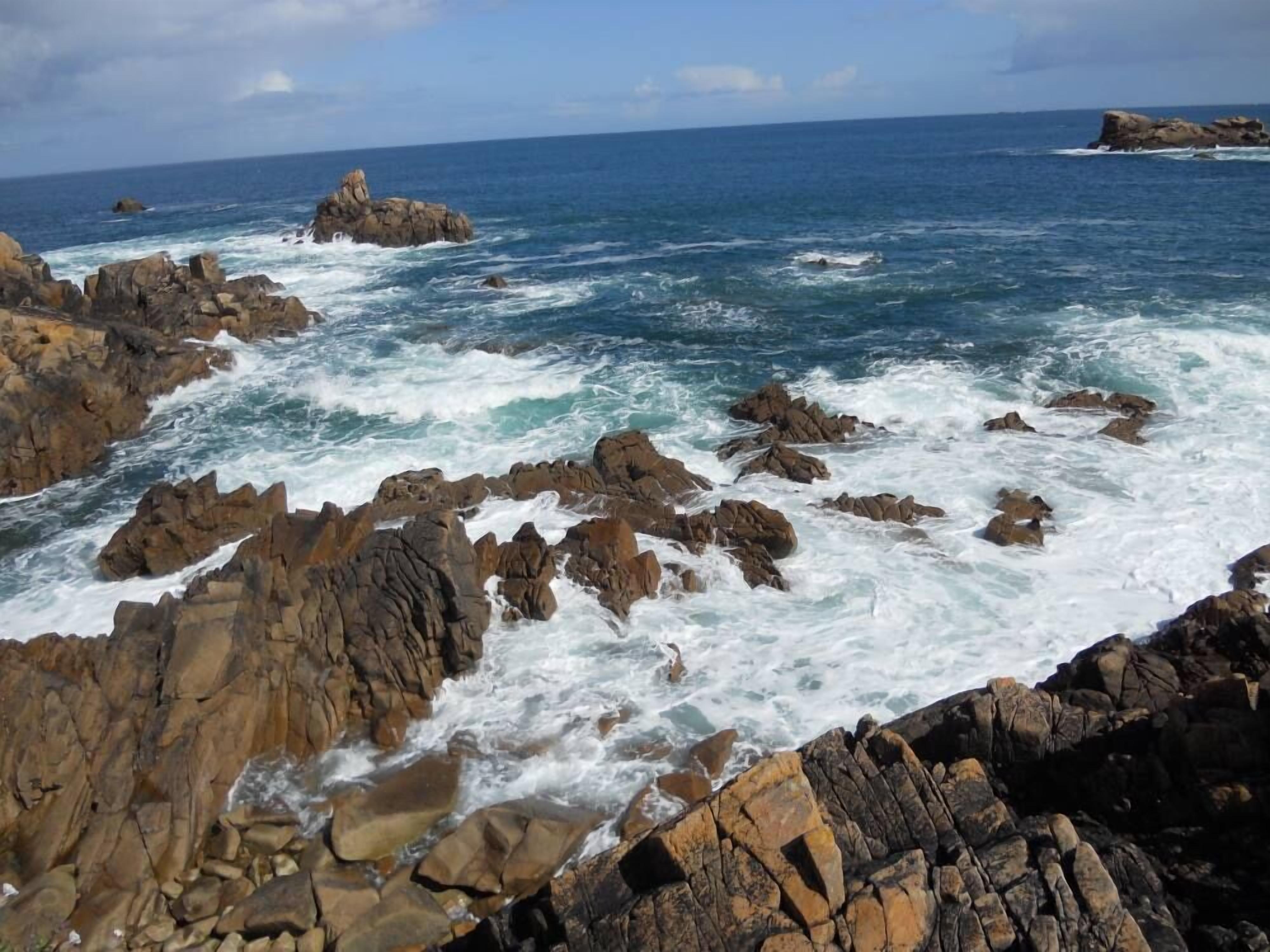 A rocky coastline with waves crashing against the rocks.