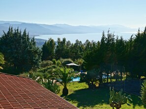 A view of a mountainous landscape with a pool area surrounded by lush greenery and cacti.